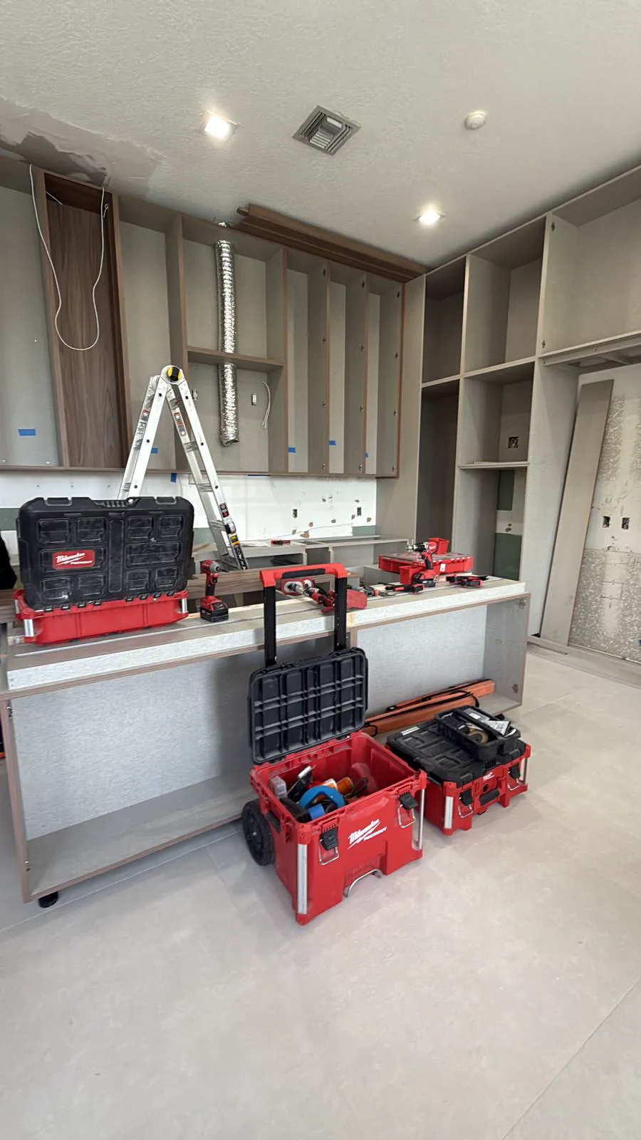 Cabinet frames installed with tools staged during a kitchen build-out