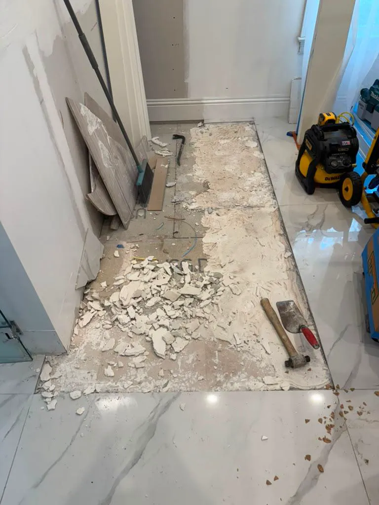 Old tile being removed to prepare the slab for new flooring