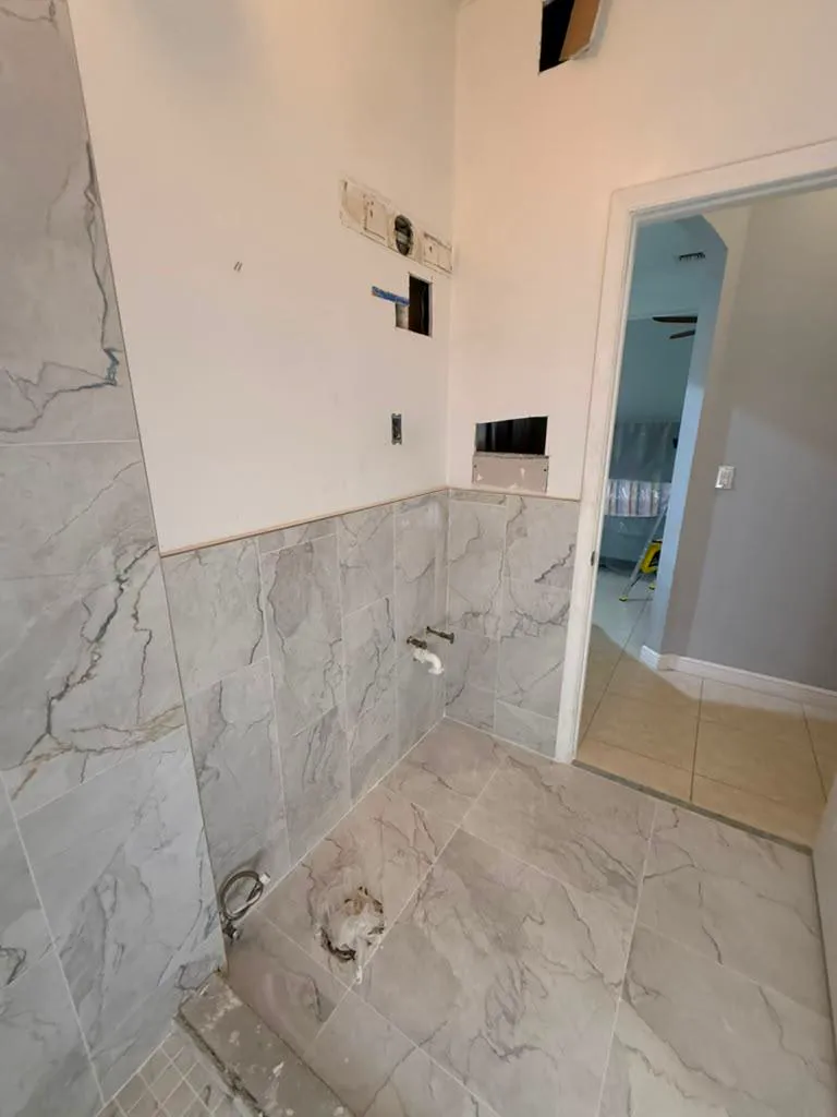 Marble-look wall tile installed partway up a bathroom wall