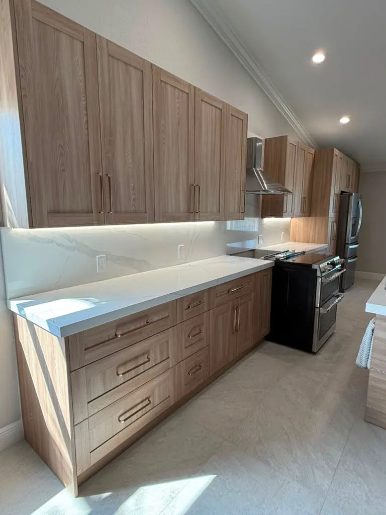 Finished oak shaker kitchen with white quartz counters and integrated lighting