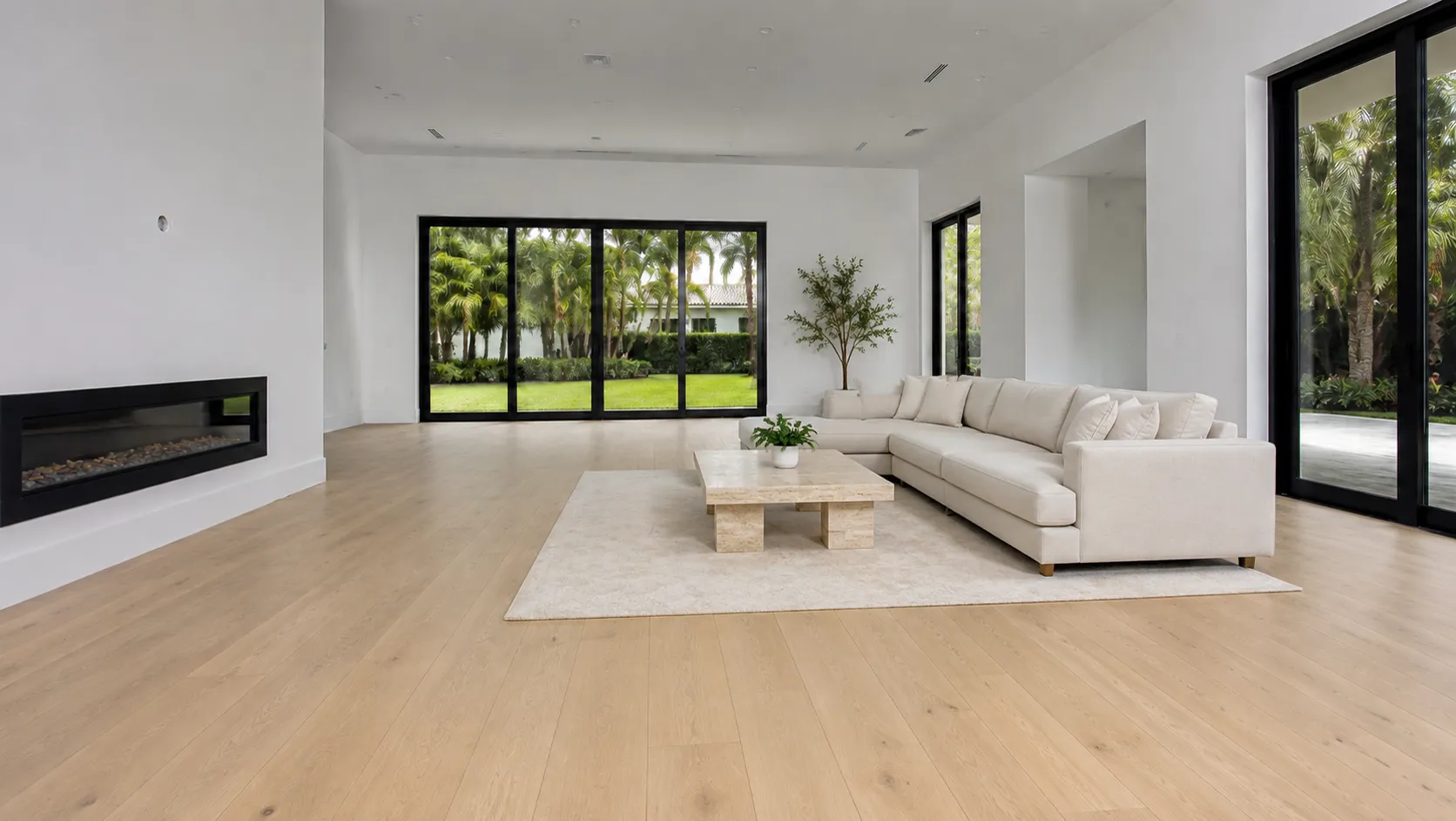 Minimal living room with wide-plank oak flooring, linear fireplace, and garden view
